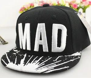 Detalle del bordado MAD y diseño de salpicaduras de pintura en gorra negra plana