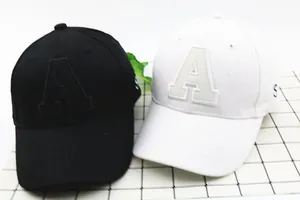 Detail view of black and white baseball caps with letter A embroidery in cotton twill