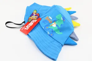 Close-up of blue cotton kids sun hat featuring green dinosaur print and 3D fin details