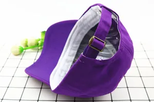 Detail view of the purple cotton baseball cap with vintage bronze metal buckle and inner tag