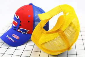 Close-up of kids dinosaur mesh caps showing breathable mesh and colorful flat lay design