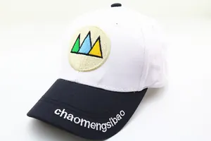Détail de la casquette bicolore avec broderie de montagne et texte sur le bord