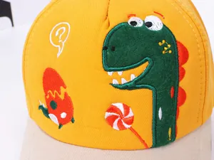 Détail d'une casquette enfant jaune avec broderie dinosaure de haute qualité