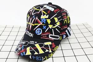 Detailed close-up of a black cotton baseball cap with colorful street graffiti art prints