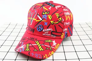 Close-up of red kids baseball cap with street style graffiti art and yellow lettering