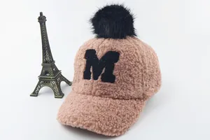 Detail of soft pink sherpa baseball cap with fuzzy black pompom and M embroidery