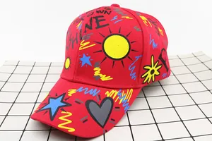Detail view of the colorful letter graffiti and sun prints on a red kids baseball cap