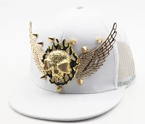 Detail of white mesh hip hop cap with gold metal skull wings and punk style rivets