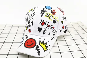 Detailed view of colorful street style graffiti and slogans on a white cotton baseball cap