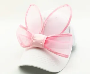 Détail de la casquette blanche en coton avec oreilles de lapin en tulle rose et nœud
