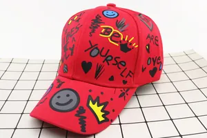 Detail of red baseball cap with graffiti prints like BE YOURSELF and ARE LOVED