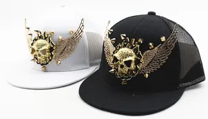Close-up of golden metal skull and rivet wings on the front of a flat brim hip-hop cap