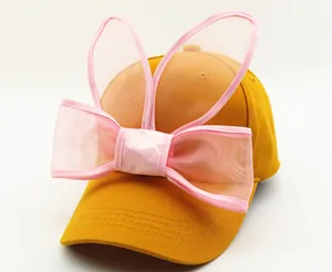 Détail de la casquette en coton gingembre avec oreilles de lapin en tulle rose et nœud