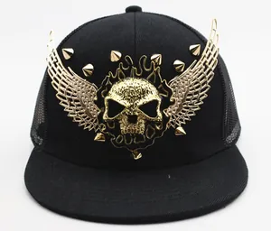 Detail of black trucker cap featuring a large gold 3D skull, wings, and punk style rivets