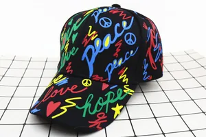 Detail of street style graffiti print with Peace and Love text on kids black cotton cap