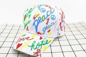 Detail of white cotton baseball cap with colorful graffiti and peace symbol print