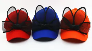 Détail de casquettes enfant colorées avec grandes oreilles en tulle et nœud noir