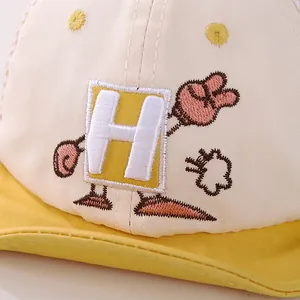 Vista de detalle de la gorra de rejilla infantil con bordado de dibujos H y costuras