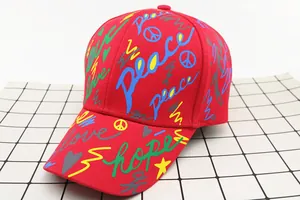 Detail of red graffiti baseball cap with Peace Love Hope print and twill cotton texture