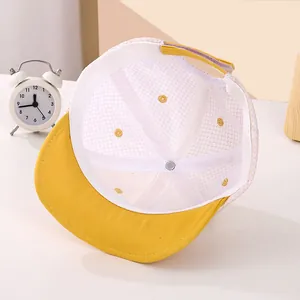 Detalle de gorra de malla amarilla para bebé con bordado de estrella y correa ajustable