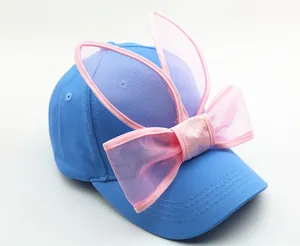 Détail d'une casquette bleue pour enfants avec oreilles de lapin et nœud en tulle