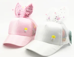 Close-up of pink and white mesh caps featuring sequined bunny ears and potato patch decoration