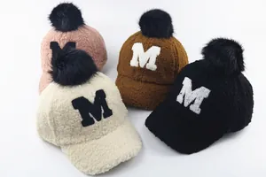 Detailed texture of plush winter baseball caps with pom-poms and M embroidery