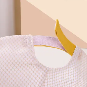 Detalle de gorra rosa de rejilla con cierre ajustable de velcro amarillo en la parte posterior