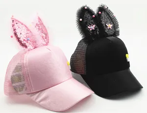 Detail of kids pink and black mesh baseball caps featuring sequin rabbit ears and bows