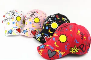 Multiple kids baseball caps with colorful graffiti patterns and sunshine lettering