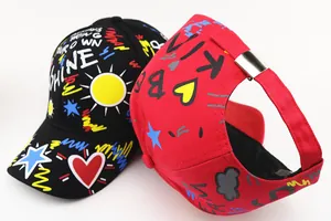 Detail view of colorful graffiti prints and adjustable metal buckle on kids baseball caps