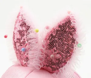 Detailed view of pink sequins, lace mesh, and beads on children's rabbit ear sun hat