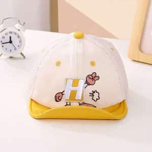 Detalle de gorra de béisbol para bebé con malla transpirable y bordado amarillo letra H
