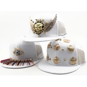 Three white punk trucker hats with gold skulls, metal spikes, and evil eye embellishments