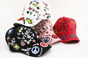 Close-up of kids graffiti print baseball caps in black, white, pink and red colors