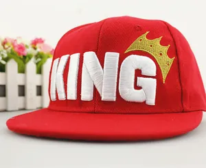 Close-up of red KING baseball cap with white 3D letter embroidery and golden crown detail