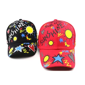 Kids graffiti baseball caps in black and red with sunshine prints and curved brims