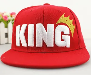 Detail of red snapback hat with 3D white KING embroidery and golden crown icon