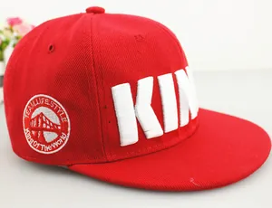 Detailed close-up of red kids KING snapback with 3D embroidery and side badge design