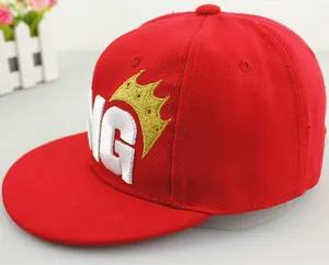 Detailed close-up of King letter embroidery and gold crown on red cotton snapback cap