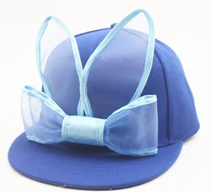 Close-up of kids baseball cap with blue mesh rabbit ears and a large decorative bow