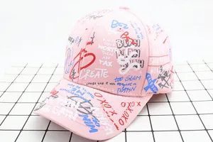 Detail van roze katoenen baseballcap met graffiti-print en een gebogen rand