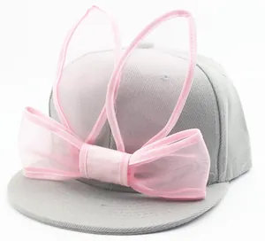 Detail of pink mesh rabbit ears and big bow on grey children's baseball cap