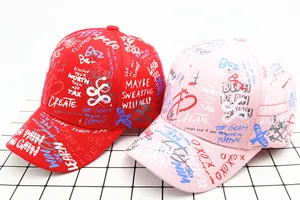Detailweergave van rode en roze katoenen baseballpetten met trendy graffiti-tekstprint