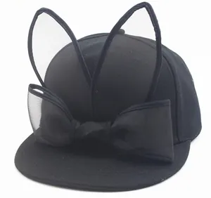 Detail of a black baseball cap featuring mesh bunny ears and a large decorative bow