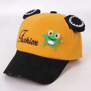 Dettaglio del cappellino giallo per bambini con patch a rana e orecchie di peluche