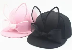 Detail of pink and black baseball caps with mesh bows and cute rabbit ear decorations