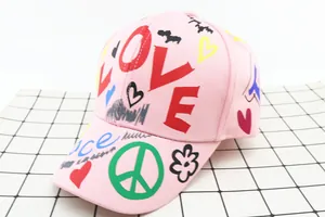 Dettaglio del berretto in cotone rosa con stampe graffiti colorate LOVE e Peace