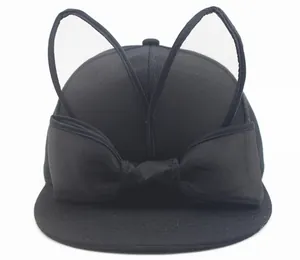 Close-up of black baseball cap with mesh rabbit ears and a large decorative bow