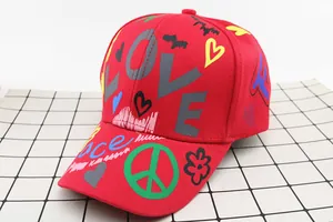 Dettaglio del cappellino in cotone rosso con stampa LOVE e graffiti colorati vivaci